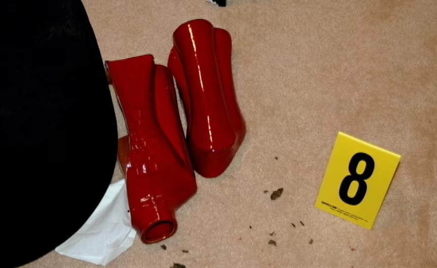 a pair of red high heels sit next to a yellow card with the number 8 on it