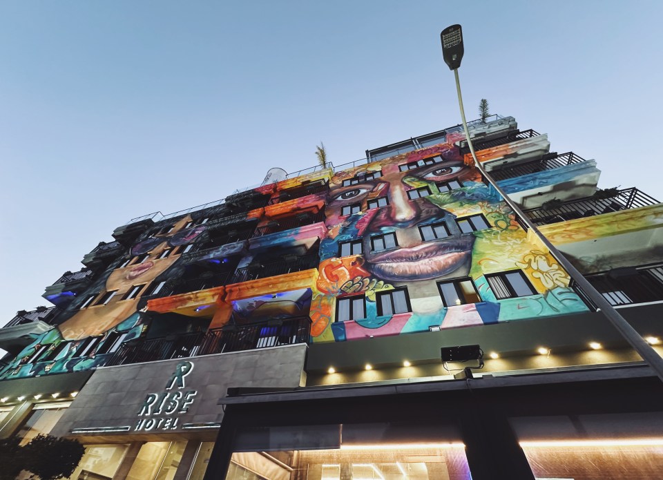 the rise hotel has a large mural on the side of it