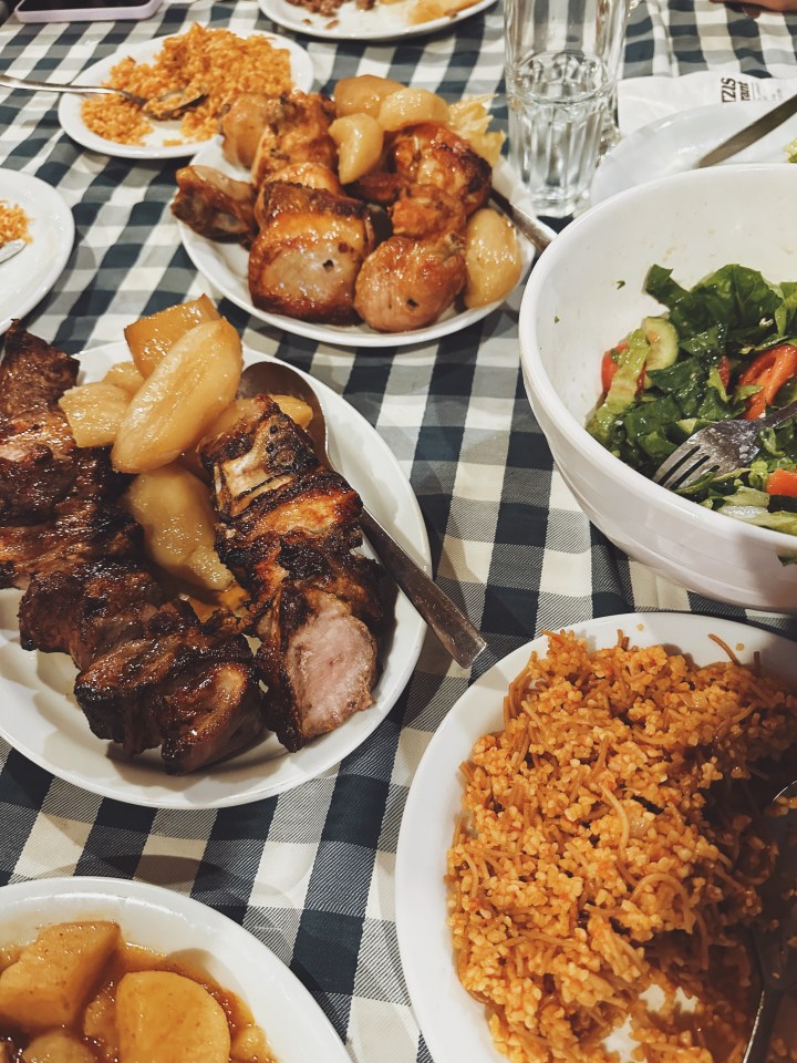 a table topped with plates of food including rice and meat