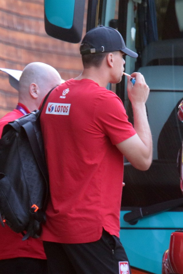 a man wearing a red shirt that says lotos on the back