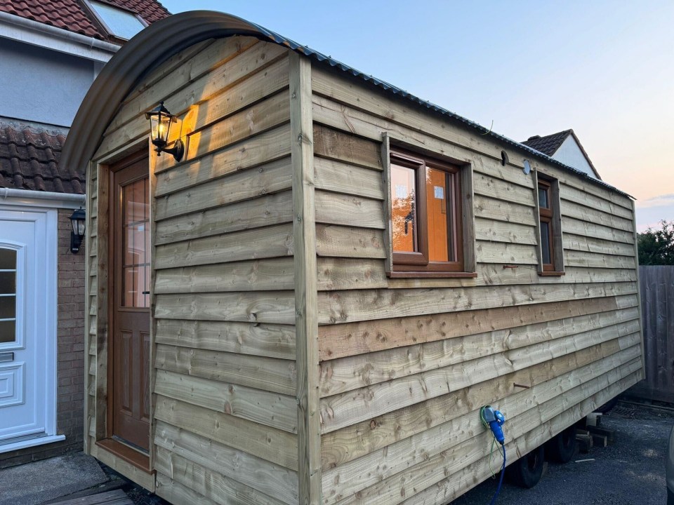 a small wooden building with a door and window