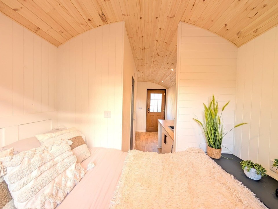 a bedroom with a bed and a potted plant