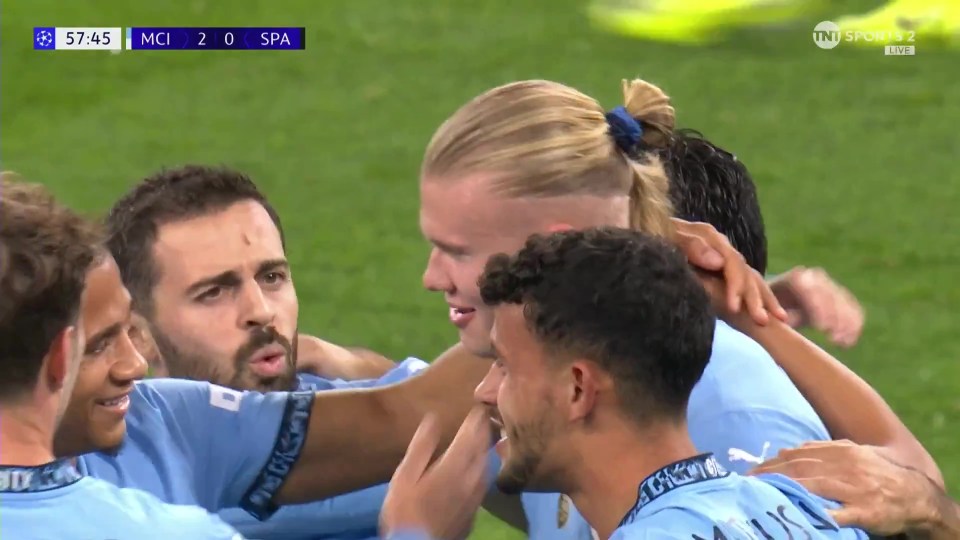 a group of soccer players huddle together on the field