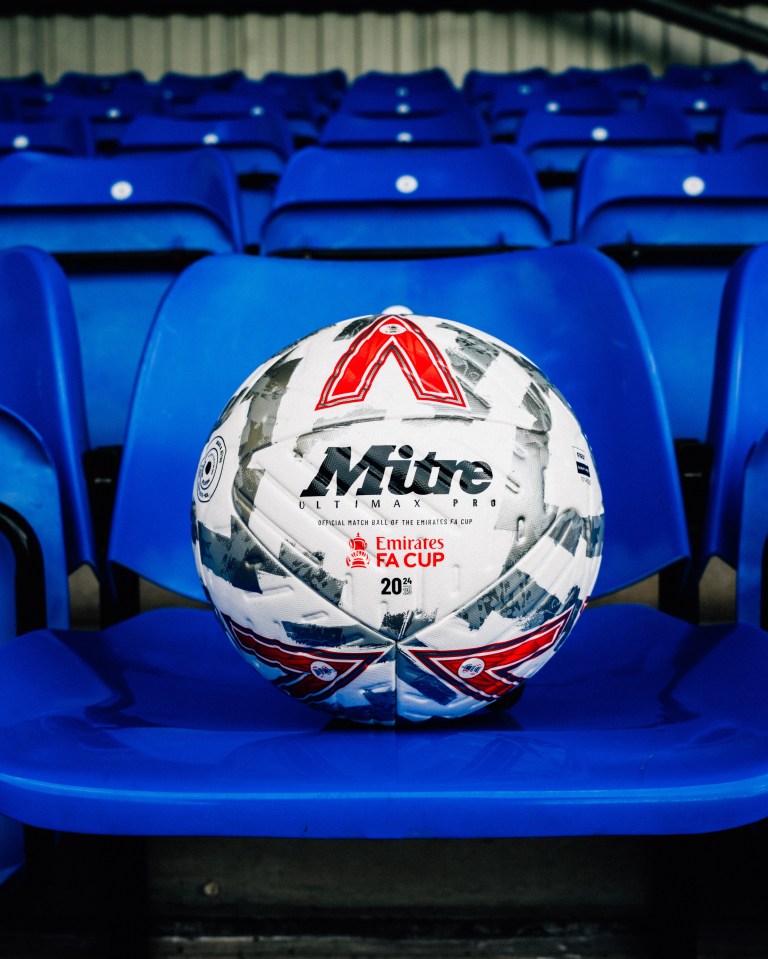 a mitre ultimate soccer ball sits on a blue chair