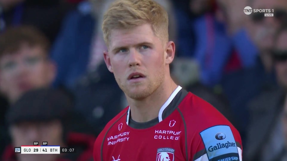 a man wearing a red hartpur college jersey