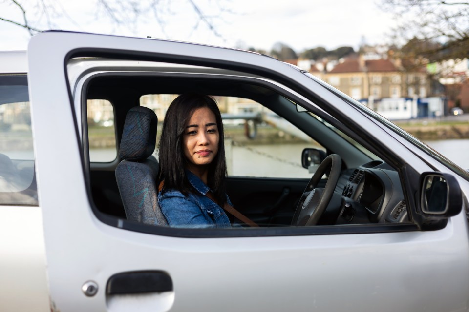 a woman is sitting in the driver 's seat of a car