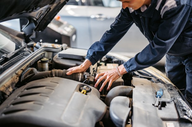 a man is working on the engine of a car