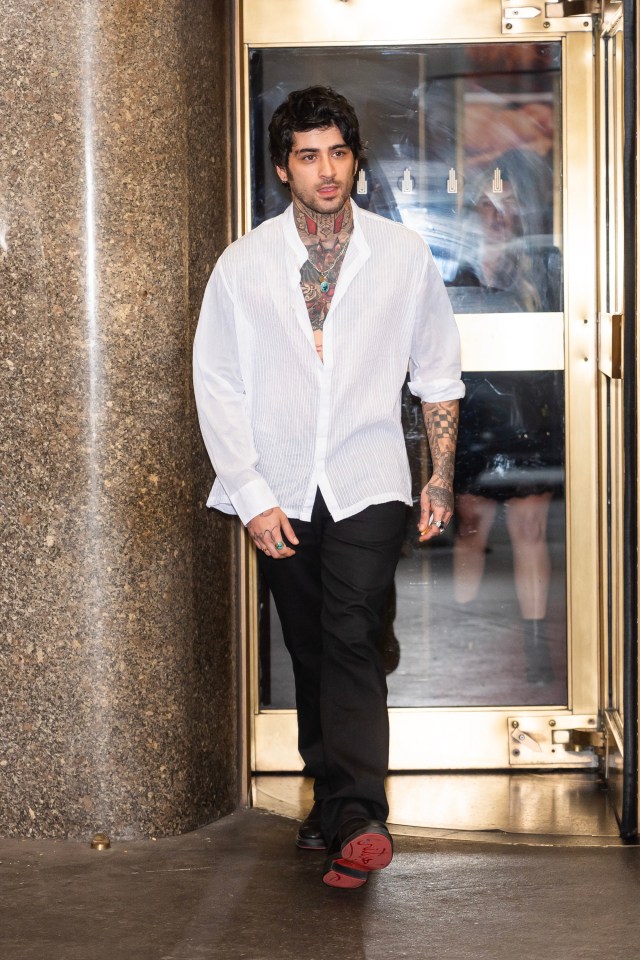 a man in a white shirt and black pants is standing in front of a glass door