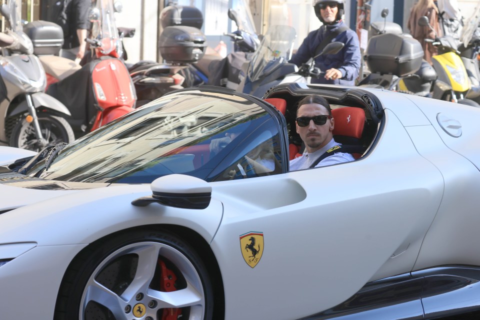 a man is driving a white ferrari sports car