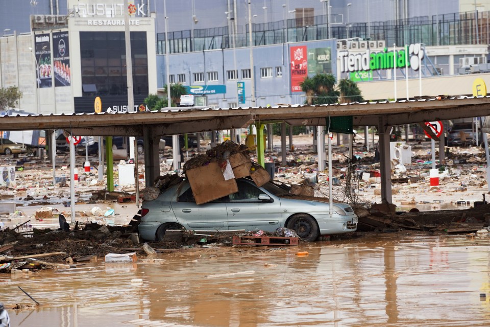 a flooded street with a sushi k restaurant in the background