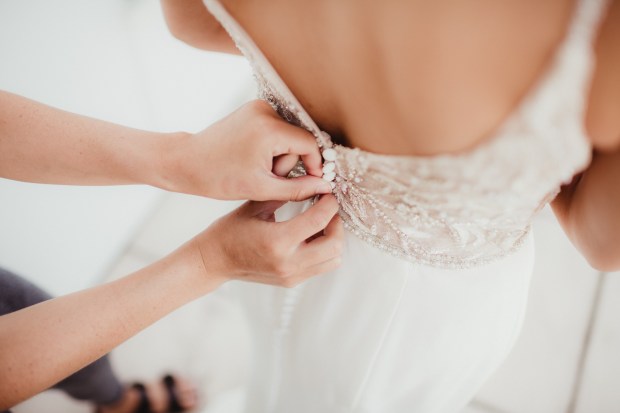 Bride getting her dress zipped up