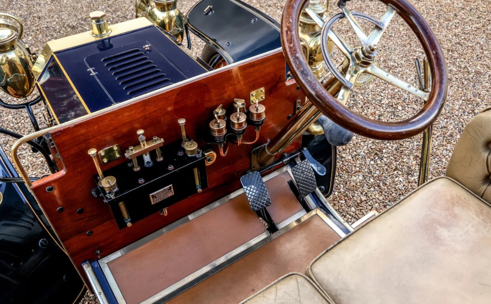 It includes a wooden steering wheel and brass oil headlights