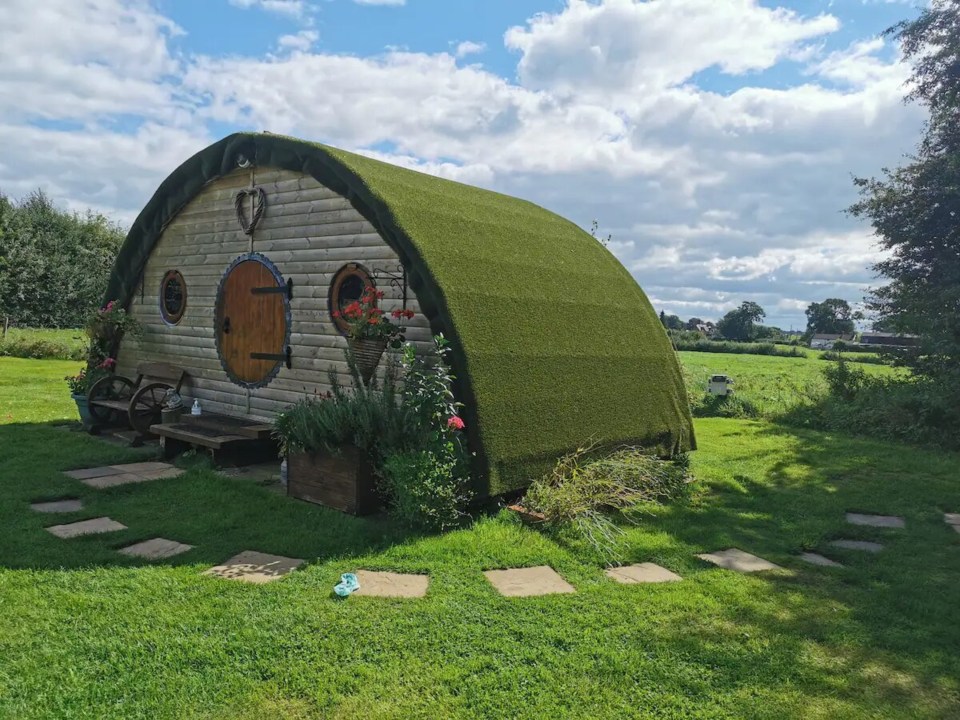 a hobbit house in the middle of a lush green field