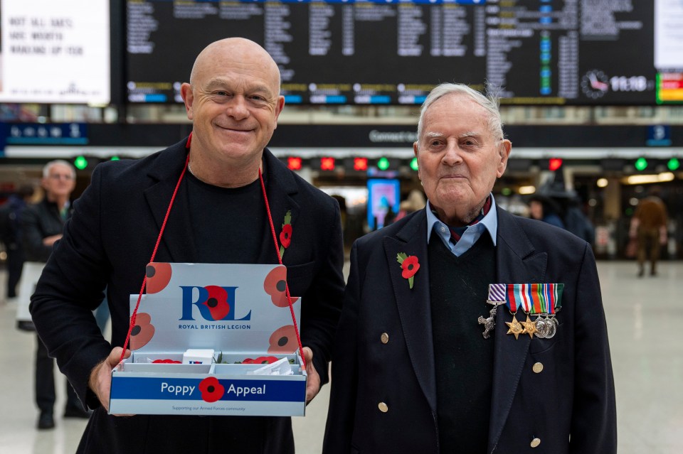 two men holding a box that says poppy appeal