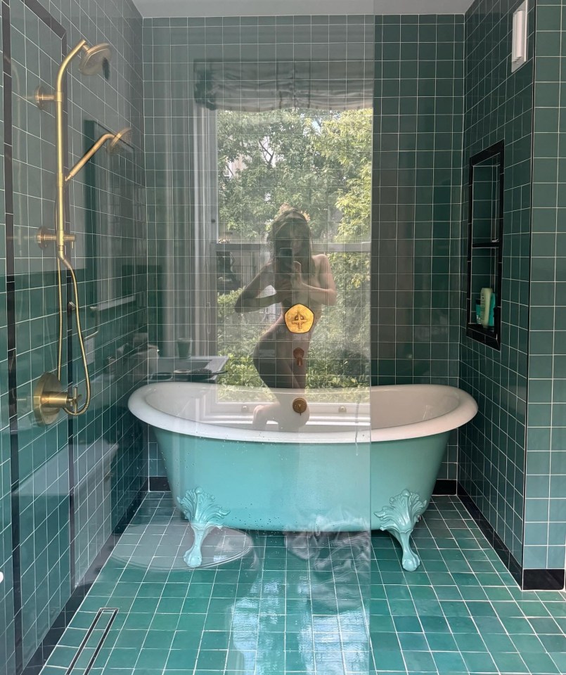 a woman taking a picture of herself in a bathtub