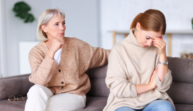 two women are sitting on a couch and one is crying