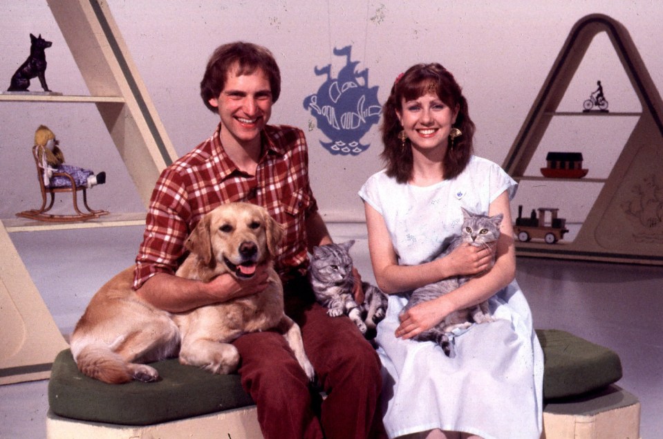 a man and a woman are posing for a picture with their pets