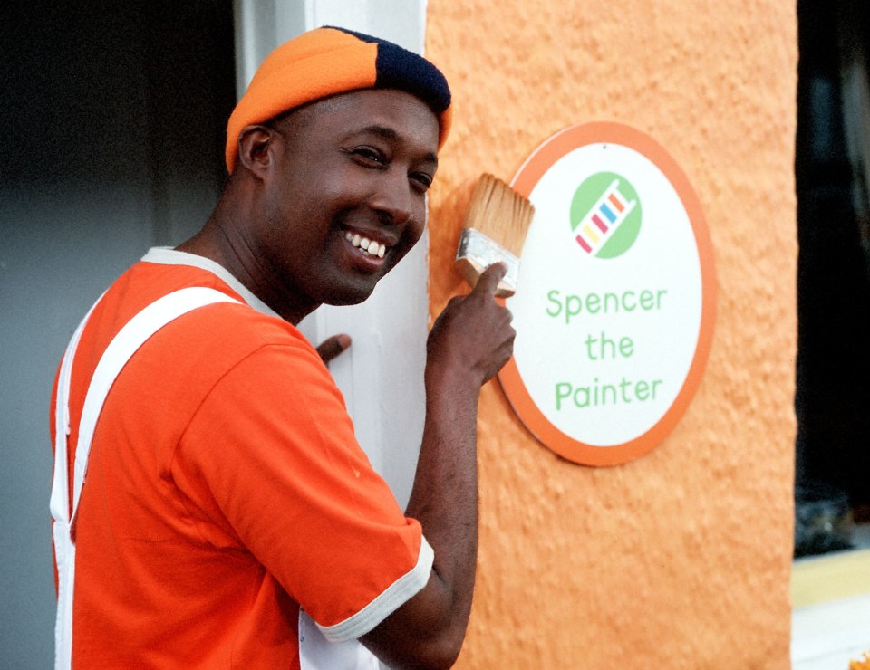 a man paints a sign that says spencer the painter