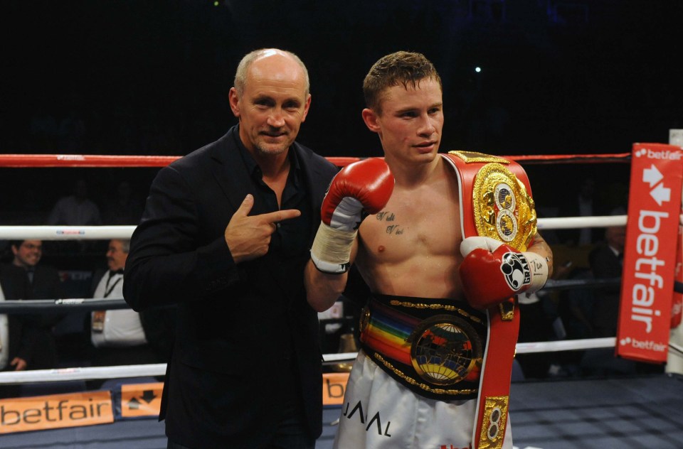 a man pointing at a boxer with a betfair sign in the background