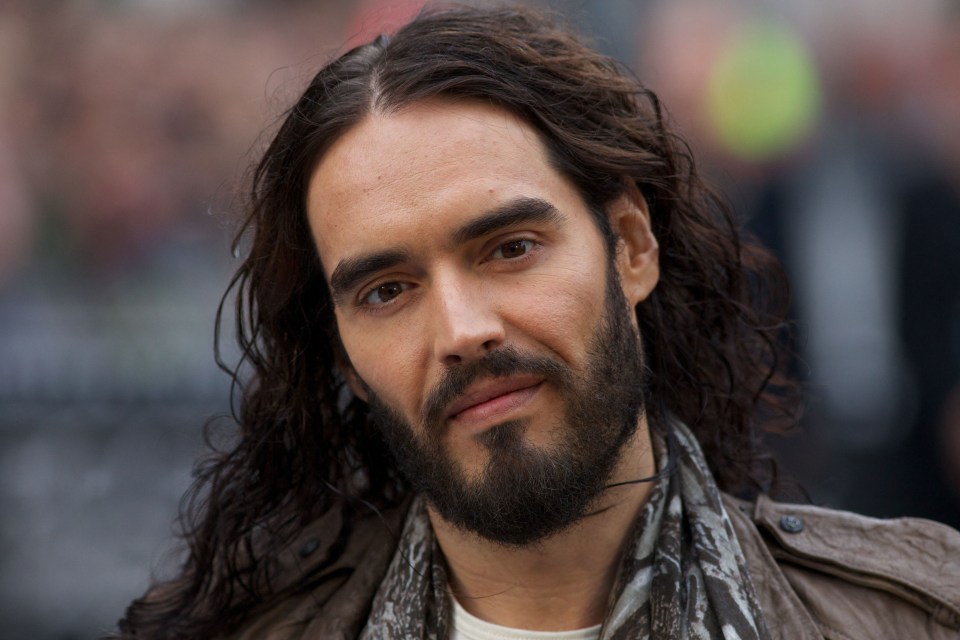 a man with long hair and a beard looks at the camera