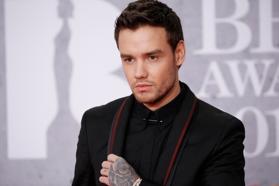 a man in a black suit is standing in front of a sign that says awards