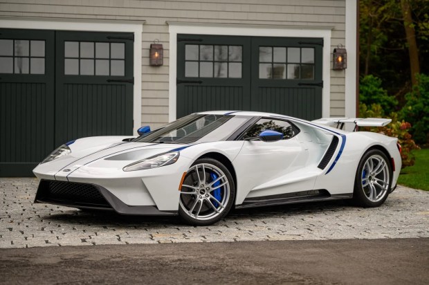 a white sports car is parked in front of a garage