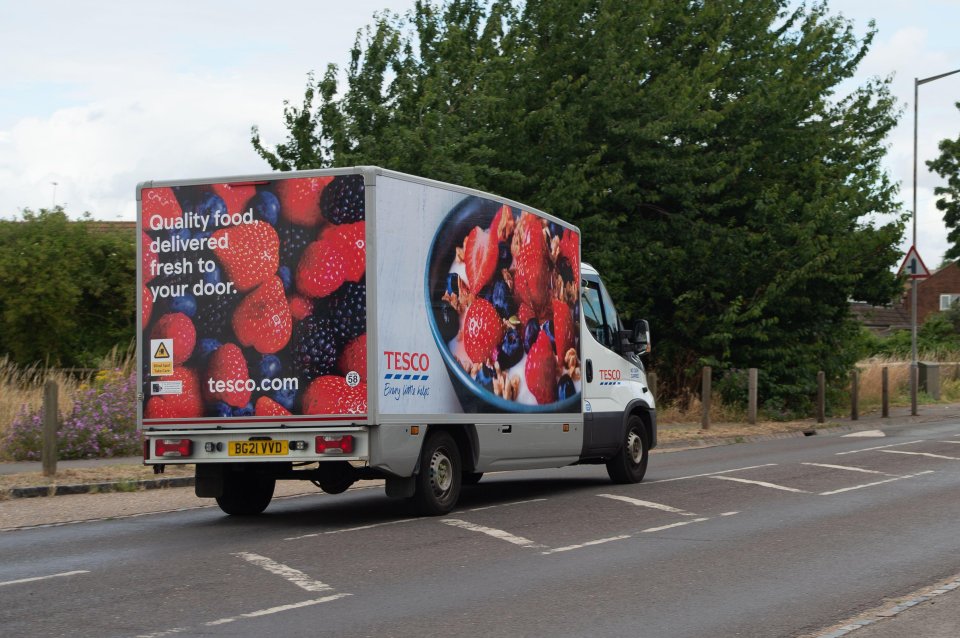 a tesco delivery truck is driving down the road