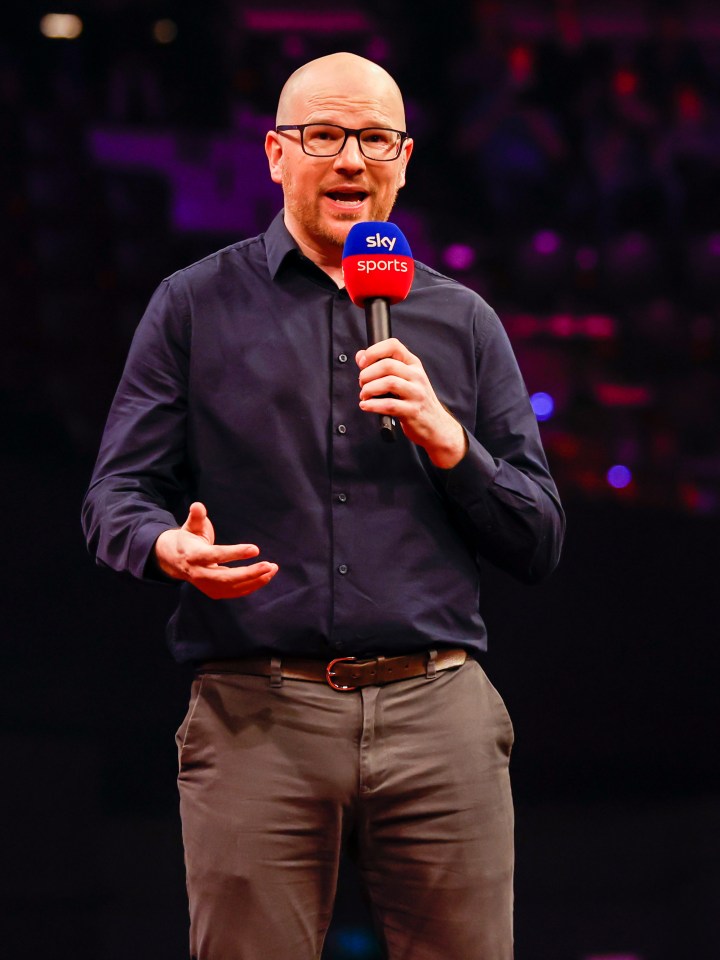 a man holding a microphone that says sky sports on it