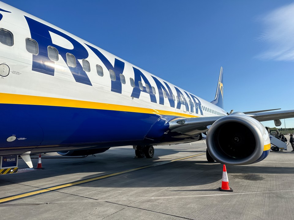 a blue and yellow ryanair plane is parked on the tarmac