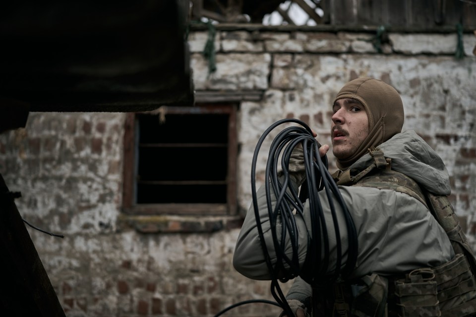 a man in a military uniform holds a bunch of wires