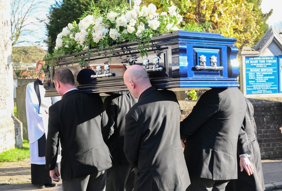 a coffin is being carried in front of a sign that says st mary the virgin