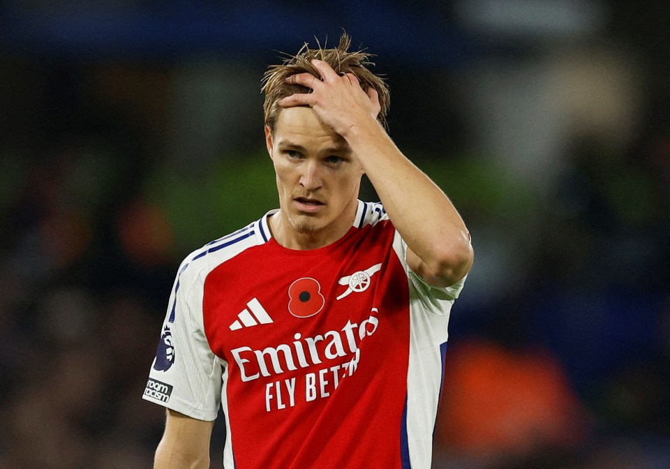 a soccer player wearing a red emirates fly bet jersey