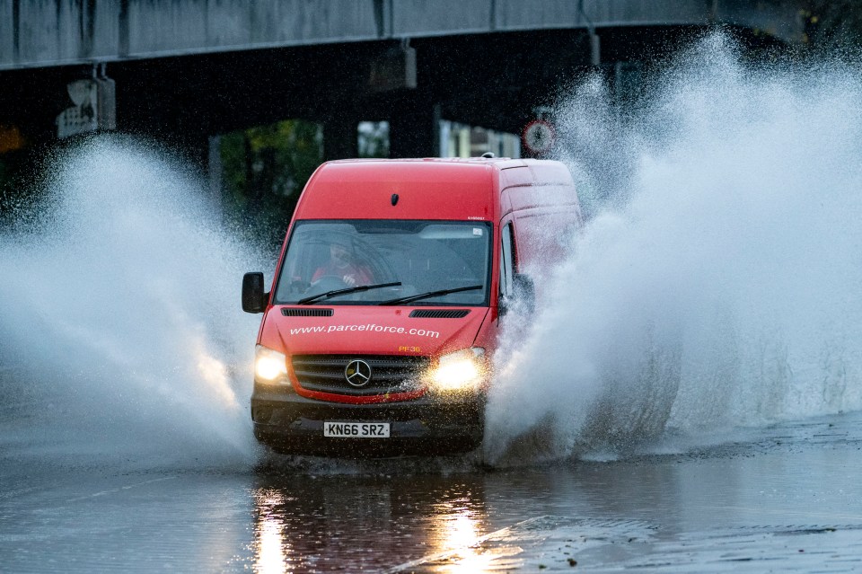 A van drives through a flooded road near Gabalfa roundabout today in Cardiff, Wales