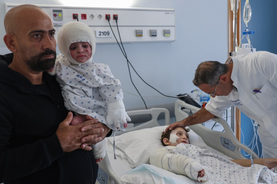 a man holding a child in a hospital room with the number 2109 on the wall