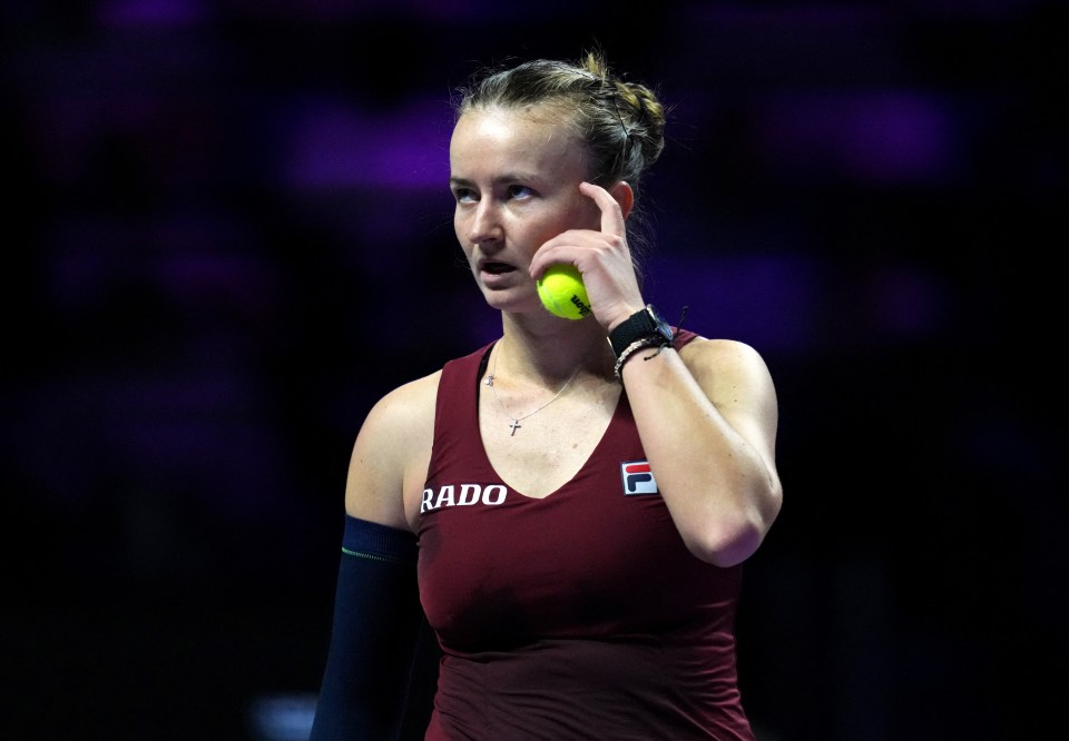 a woman holding a tennis ball with the word rado on her shirt