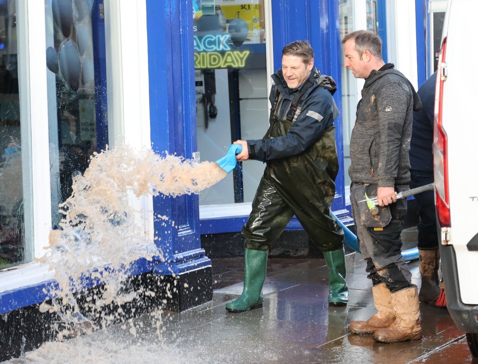 People using water hoovers in a bid to clean up the streets in Tenbury Wells