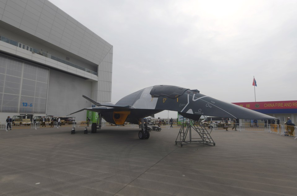 a fighter jet is parked in front of a building with a sign that says ' china ' on it