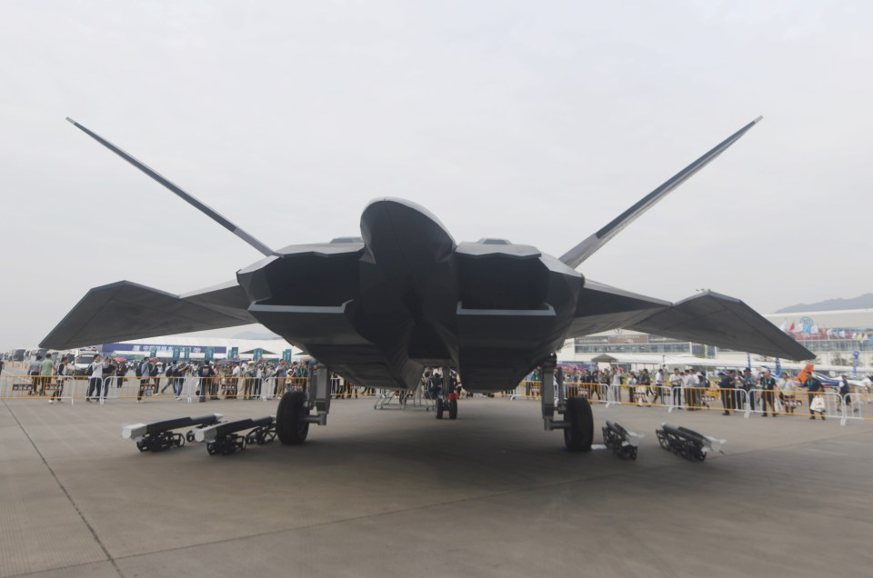 a fighter jet is on display in front of a crowd of people