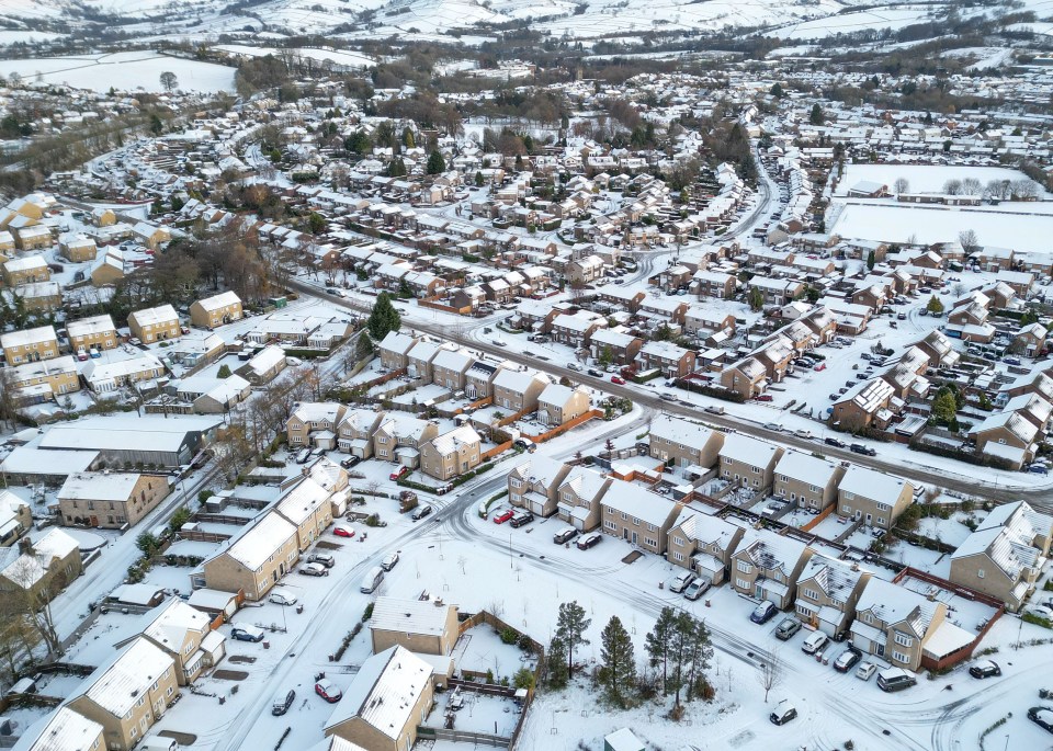 an aerial view of a city with snow on the roofs