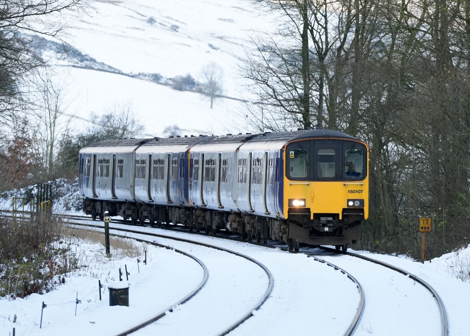 A train makes its way through the snow in the village of Dove Holes in the Peak District