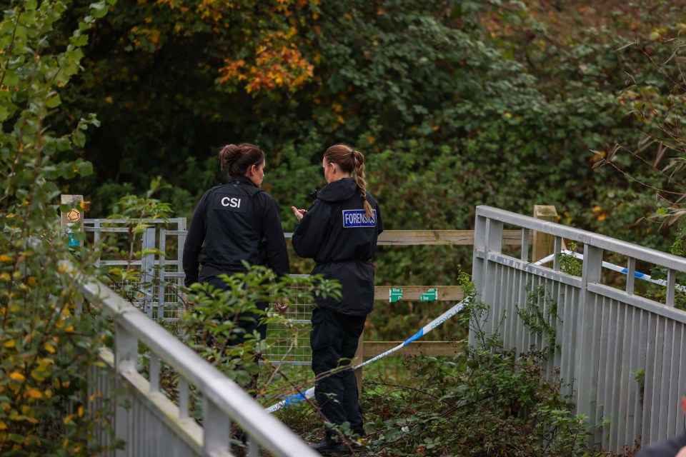 two forensics officers are walking across a bridge