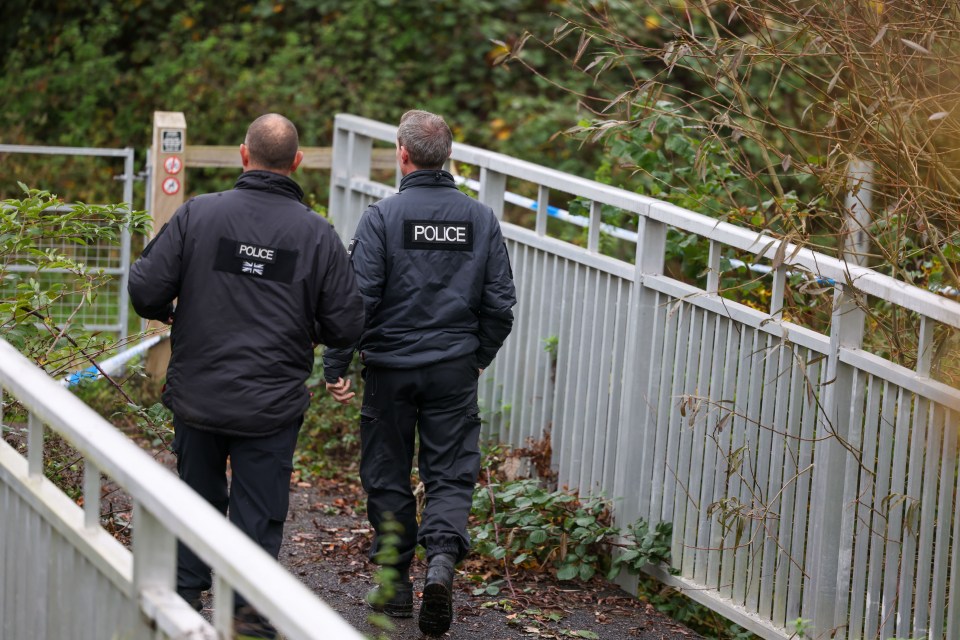 two police officers are walking across a bridge