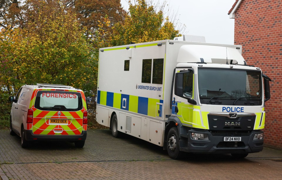 a forensics van is parked next to a police truck