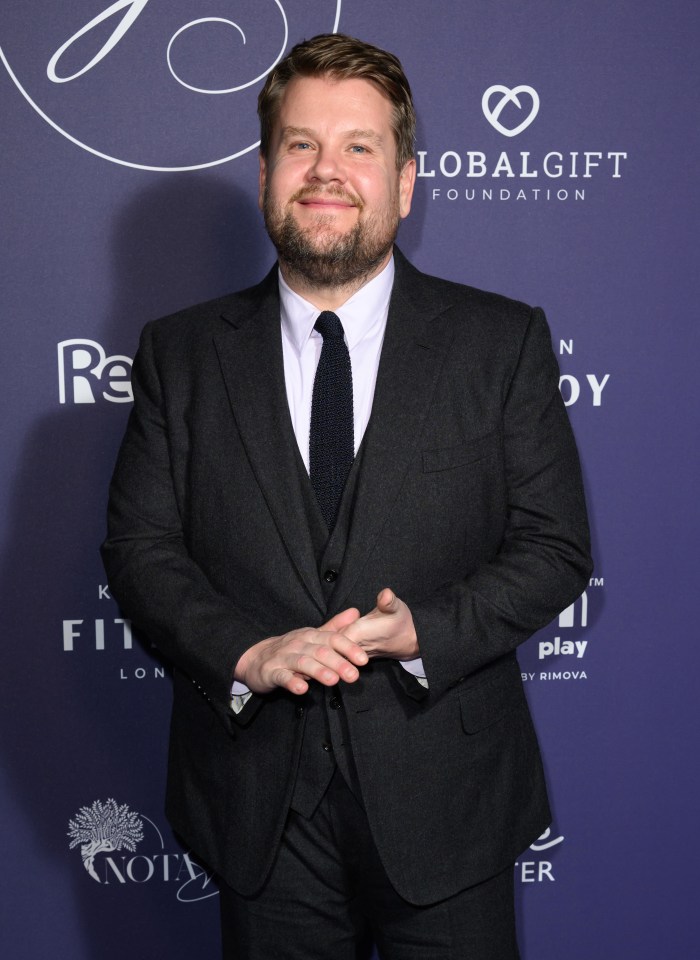 a man in a suit stands in front of a sign that says global gift foundation