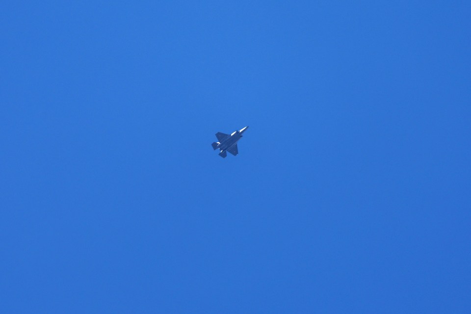 a fighter jet is flying through a clear blue sky