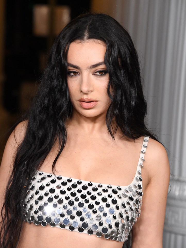 a close up of a woman wearing a silver top