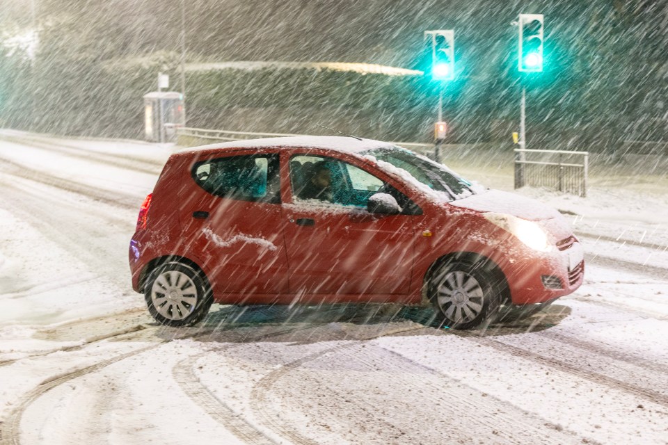 Drivers struggling through the heavy snow falling in Leeds, Yorkshire, yesterday morning