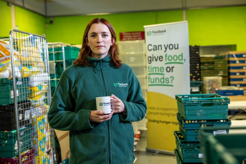 a woman in a green freebank jacket holds a mug