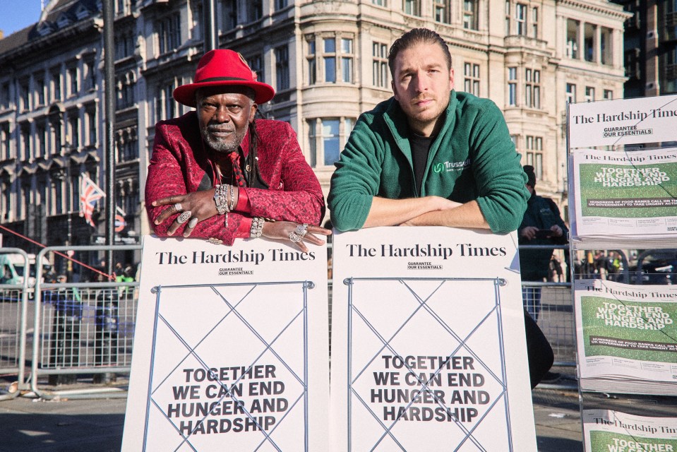 a man in a red hat stands next to a man holding a sign that says together we can end hunger and hardship