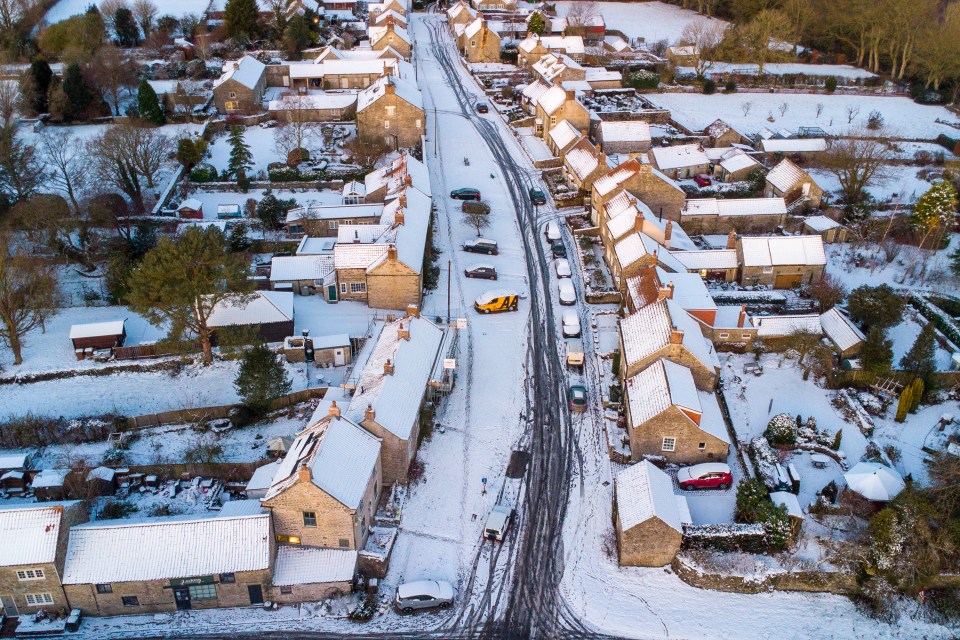 an aerial view of a village covered in snow